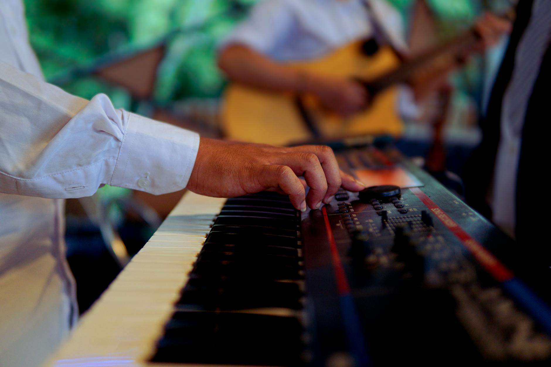 Musician adjusting an electronic keyboard during a live performance